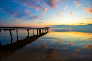 Fototapeta na wymiar Sunrise at an old wooden jetty on the Fleet lagoon