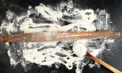 very old wooden rolling pin on a black background, top view