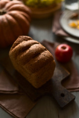 Grain bread, red apples and pumpkin on a festive table