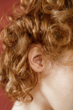 Curly hair and ear of ginger woman