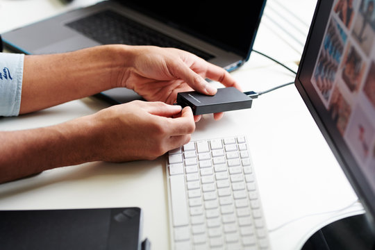 Crop man inserting memory drive