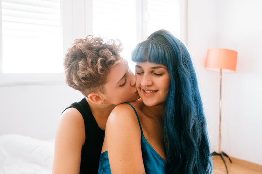 Lesbian couple comfortable in their bright white room