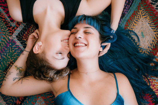 two lesbian girls lying on a colorful carpet