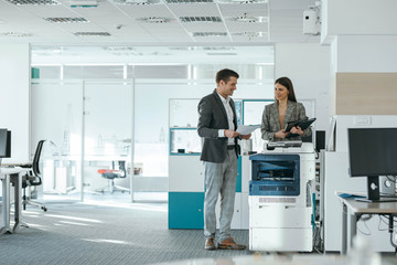 Colleagues Chatting by the Copy Machine