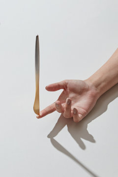 Stainless table-knife on a woman's finger on a white background