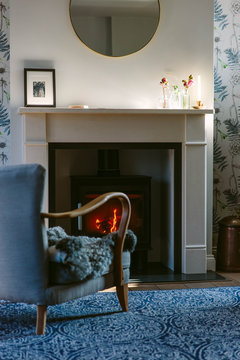 Chair in front of a wood-burner in a cosy living room