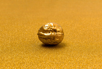 Painted golden walnut on glittering background. Christmas New year decor.