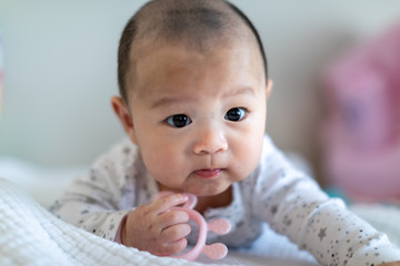 Happy six months baby boy crawling with teething toy