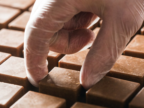 Crop pastry chef taking frozen chocolate mold