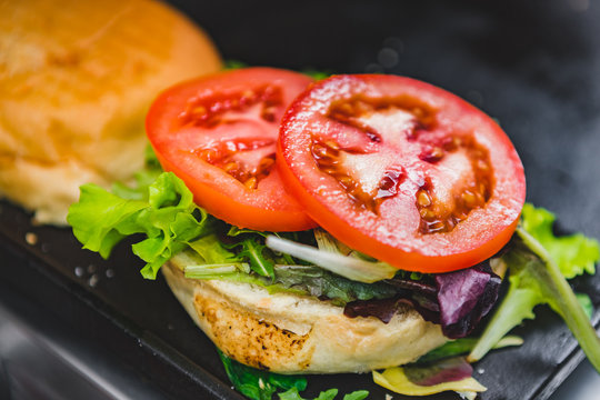 Preparing an Hamburger with Fresh Tomatoes