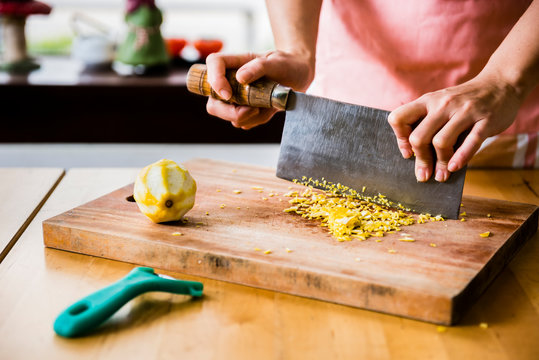 Dessert master mince lemon peel on wooden cutting board