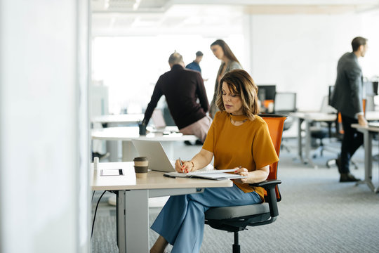 Middle-Aged Businesswoman Working at Open Space Office