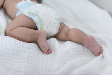 Baby legs with cloth diaper on blanket
