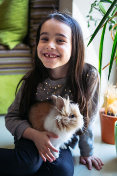 Kid playing with a pet rabbit