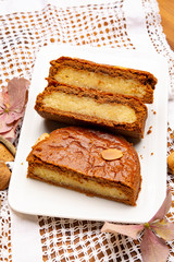 Fresh baked Dutch filled spicy cookies with almonds in autumn colors on dark wooden background