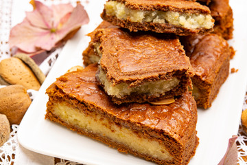 Fresh baked Dutch filled spicy cookies with almonds in autumn colors on dark wooden background