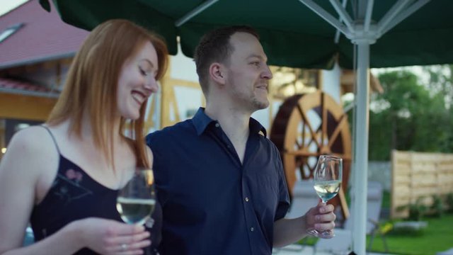 a young couple on a romantic walk in a hotel&rsquo;s garden drinking wine - ein junges Paar spaziert romantisch durch den Garten eines Hotels und trinkt Wein 4K ProRes Footage