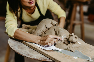 Beautiful middle age woman professional sculptor working on gorgeous sculpture.