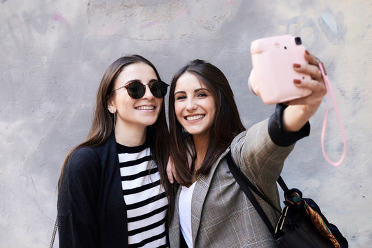 Sisters selfie with polaroid.
