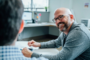 Smiling man sitting in office
