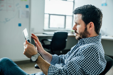 Side view of man using digital tablet in office