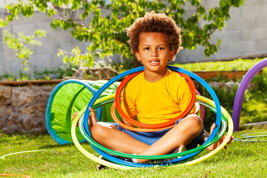 Cute curly boy portrait with color hula hoop rings