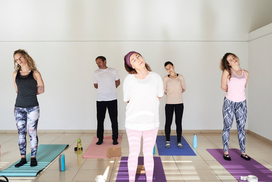 Group yoga class diverse ages.