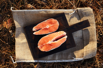 Raw salmon steaks and ingredients on a old wooden board