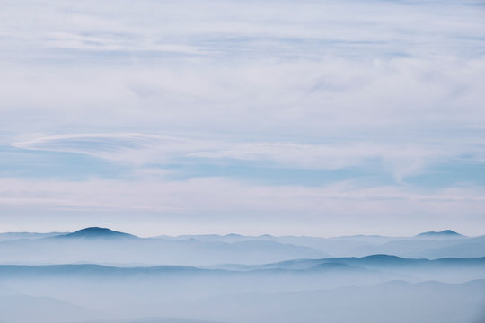 Layered mountain landscape with clouds and fog