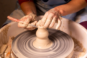 Professional potter making bowl in pottery workshop, studio.