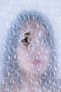 Woman face trough bubble wrap
