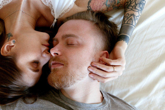 Cute couple with closed eyes on bed