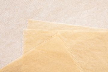 Layers of parchment paper background in two tones light tan and beige colours shot from above and close up in high resolution as textured abstract design element