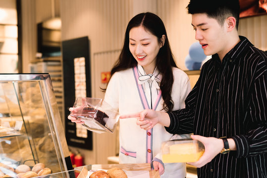 Young couple buying bakery products in store