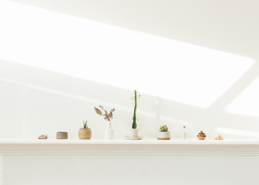 Fototapeta Still life of ceramics and green plants on fire mantle in minimalist artist studio