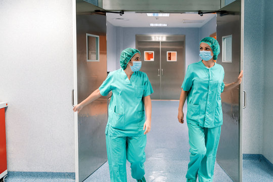 Doctors in uniform opening door in clinic