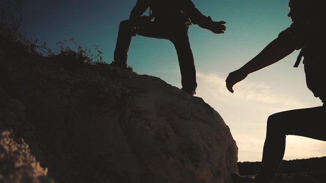 teamwork help business travel silhouette slow motion video concept. Helping hand silhouette between two climbers. teamwork group of tourists lends a helping hand climb the cliffs mountains. couple man