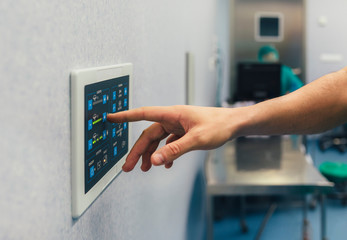 Unrecognizable man using a electronic lights control device in the operating room