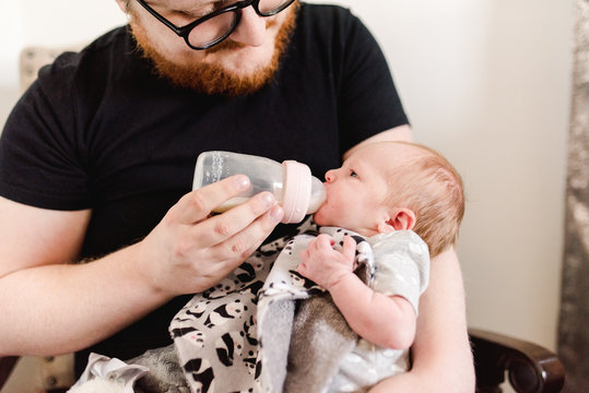 daddy giving his newborn baby the bottle