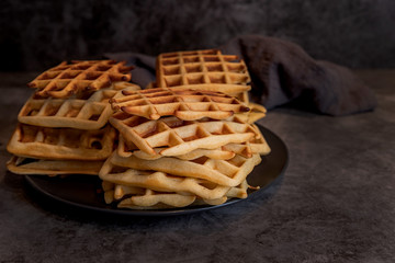 Plate of belgian waffles on dark gray background
