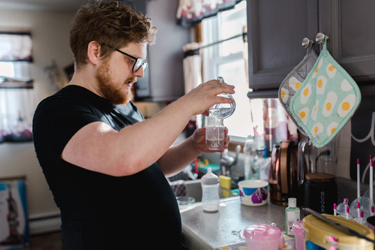 New father preparing a bottle for his newborn baby
