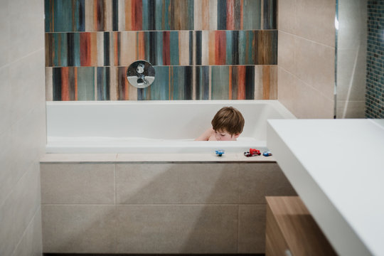 Little caucasian boy washes in the bath