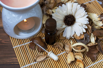 Aroma lamp with hot candles, a bottle of oil and a flower, decor in beige colors. Aromatherapy, relaxing atmosphere