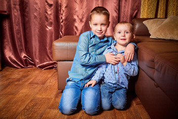 Two brothers laughing, hugging and having fun in the room. Little boys indoor