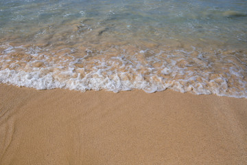 Beach sand and sea wave perspective view. Sea water tide on yellow sand. Tropical seaside concept photo.