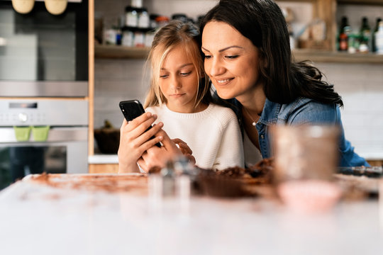 Mother and her daughter using mobile phone