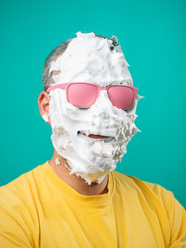 Portrait of a man with shaving foam and pink glasses