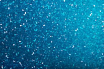 Shiny blue defocused glitter background.