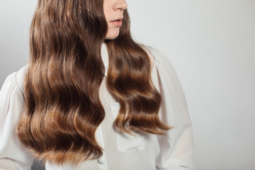 Fototapeta premium Closeup of female hands of hairdresser or coiffeur makes hairstyle. Hair