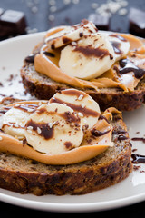 Toast with peanut butter and bananas, decorated chocolate cream and sesame